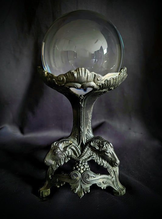 Crystal ball on a metal base with goat heads