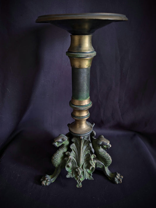 Antique metal candlestick with griffins